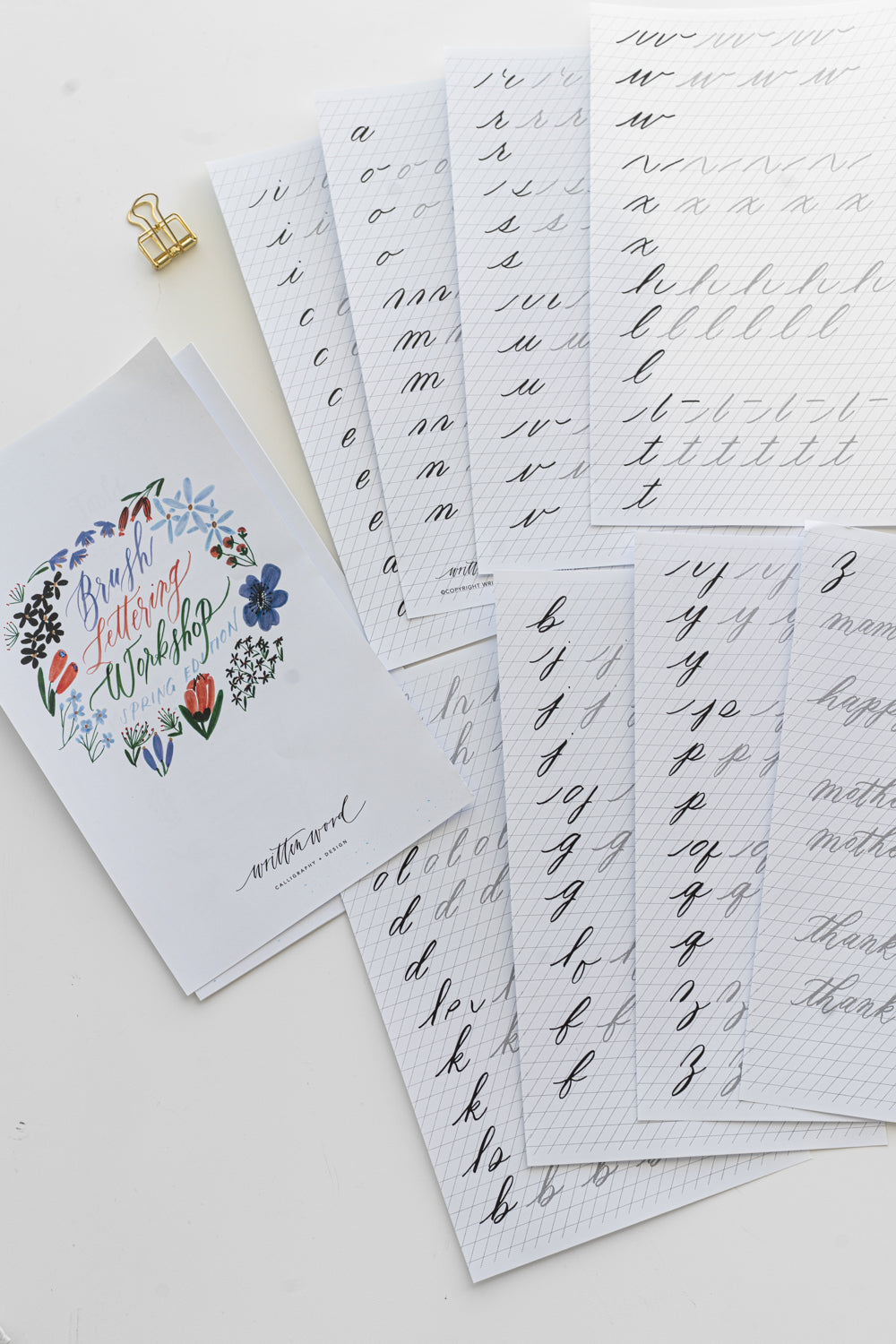 Brush lettering worksheet pages laid out next to each other on a white surface