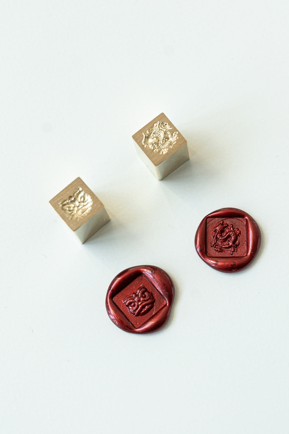 Two square mini wax seal with a lion dance head or dragon engraved with two red wax seals showcasing the designs