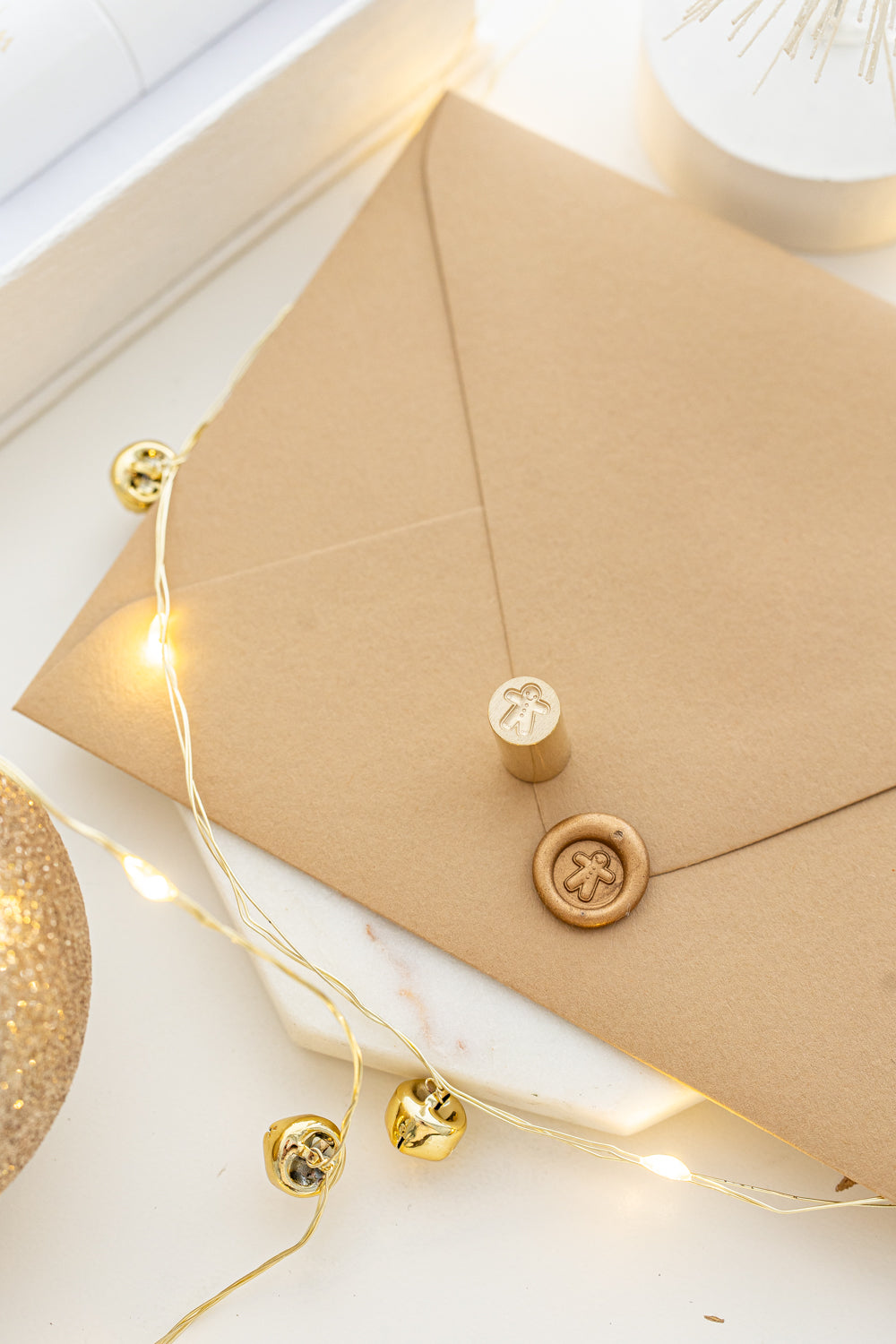 Whimsical holiday mini wax seal stamp with gingerbread man design in gold wax on a kraft envelope, part of Written Word Calligraphy’s Holiday Collection.