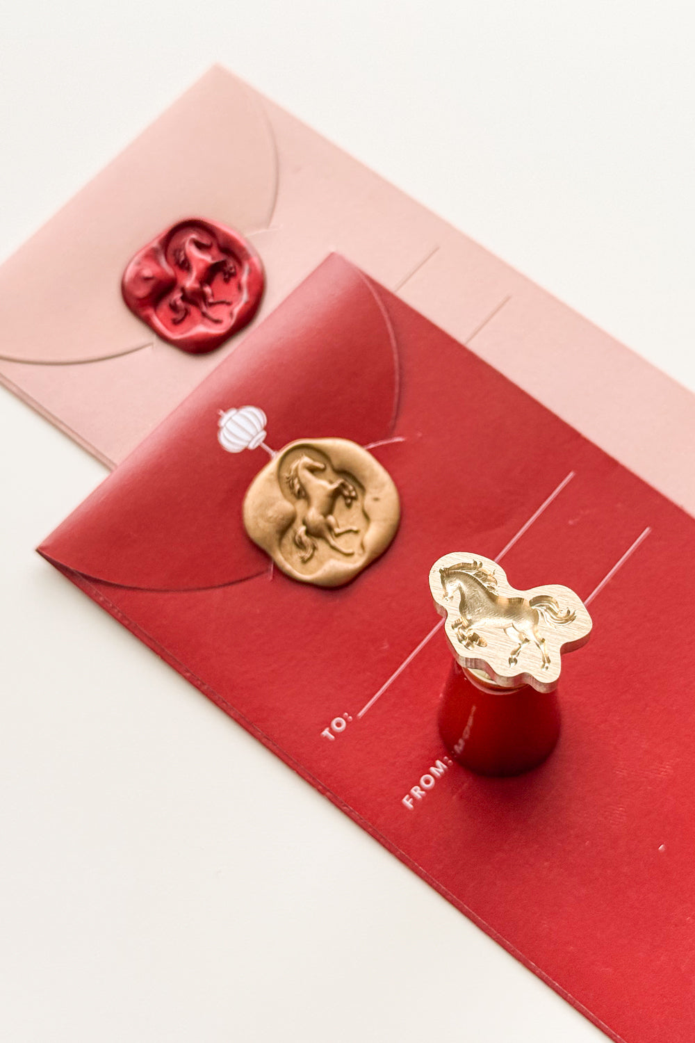 Horse wax seal on red envelope with brass stamp head for Lunar New Year stationery and sealing wax