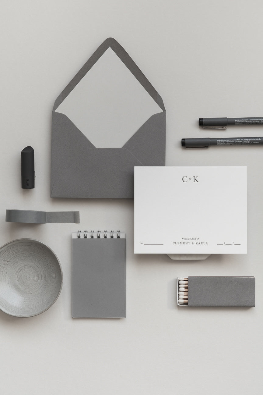 Minimalist personalized stationery set with grey envelope, card, notebook, pen and desk accessories