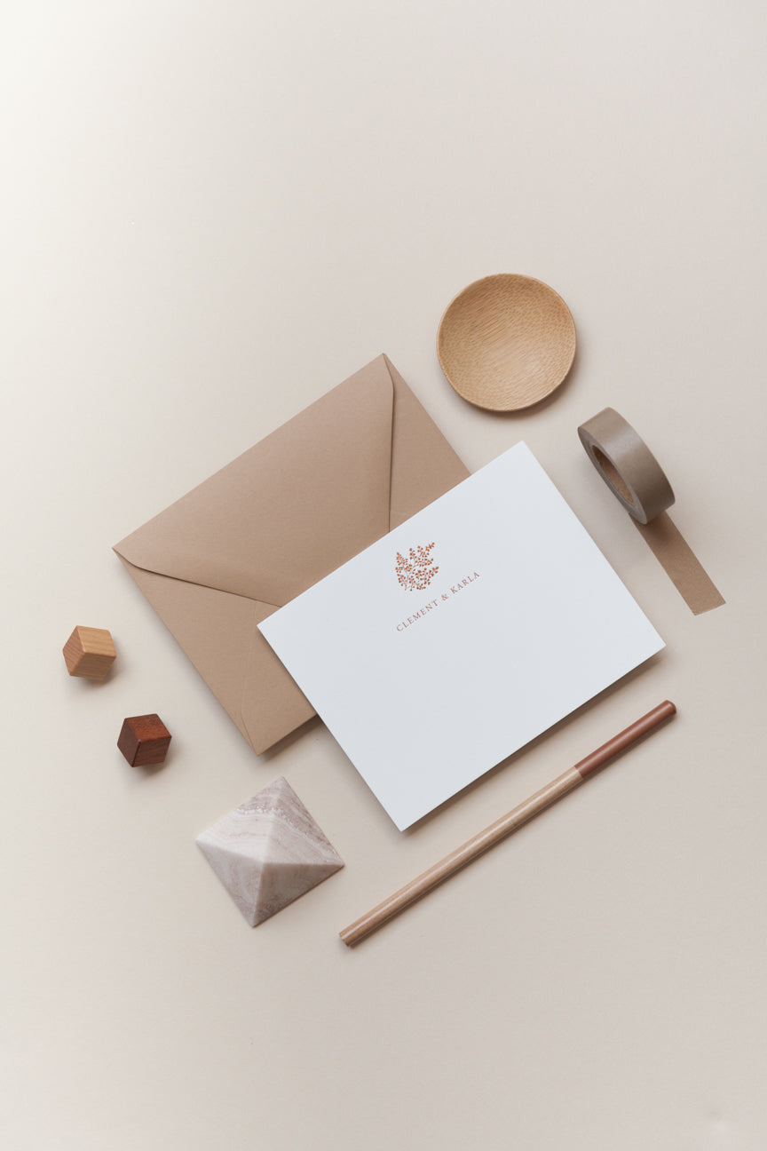 Personalized stationery flat lay with kraft envelope, card, pencil, and neutral-toned desk accessories