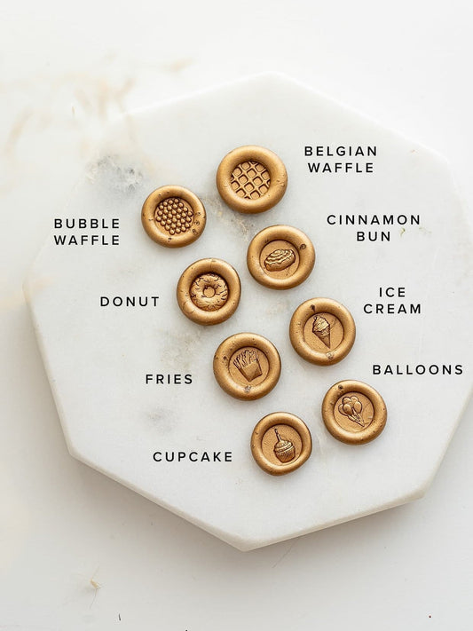 Gold wax seals featuring mini designs: donut, cupcake, fries, ice cream, cinnamon bun, waffles, bubble waffle, and balloons