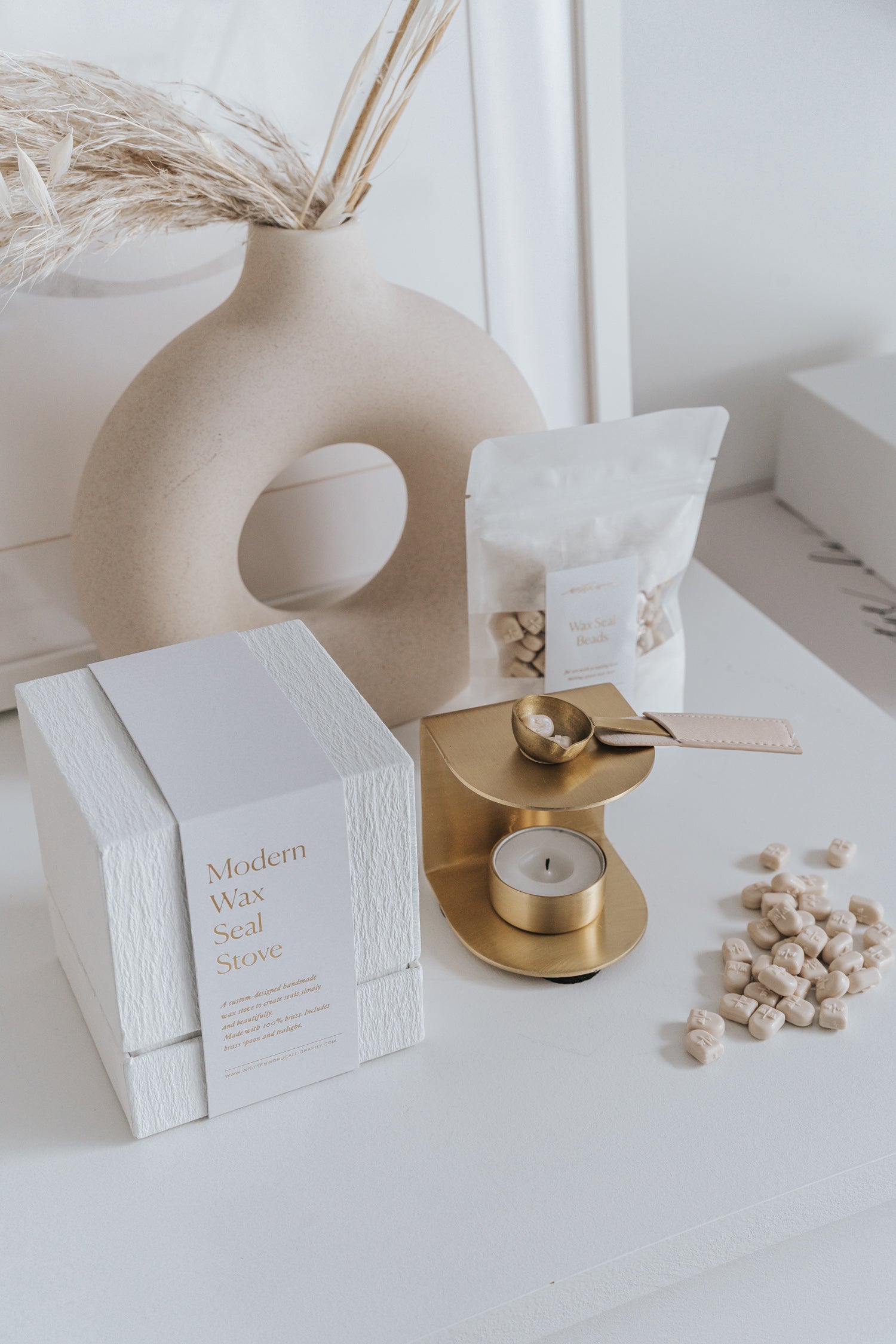 Brass wax seal stove and spoon with white box, beige wax bead pack, and loose beige wax beads.