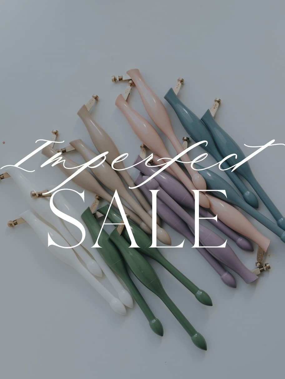 Assorted universal nib container penholders in white, green, beige, lavender, blush, and blue on a white surface.