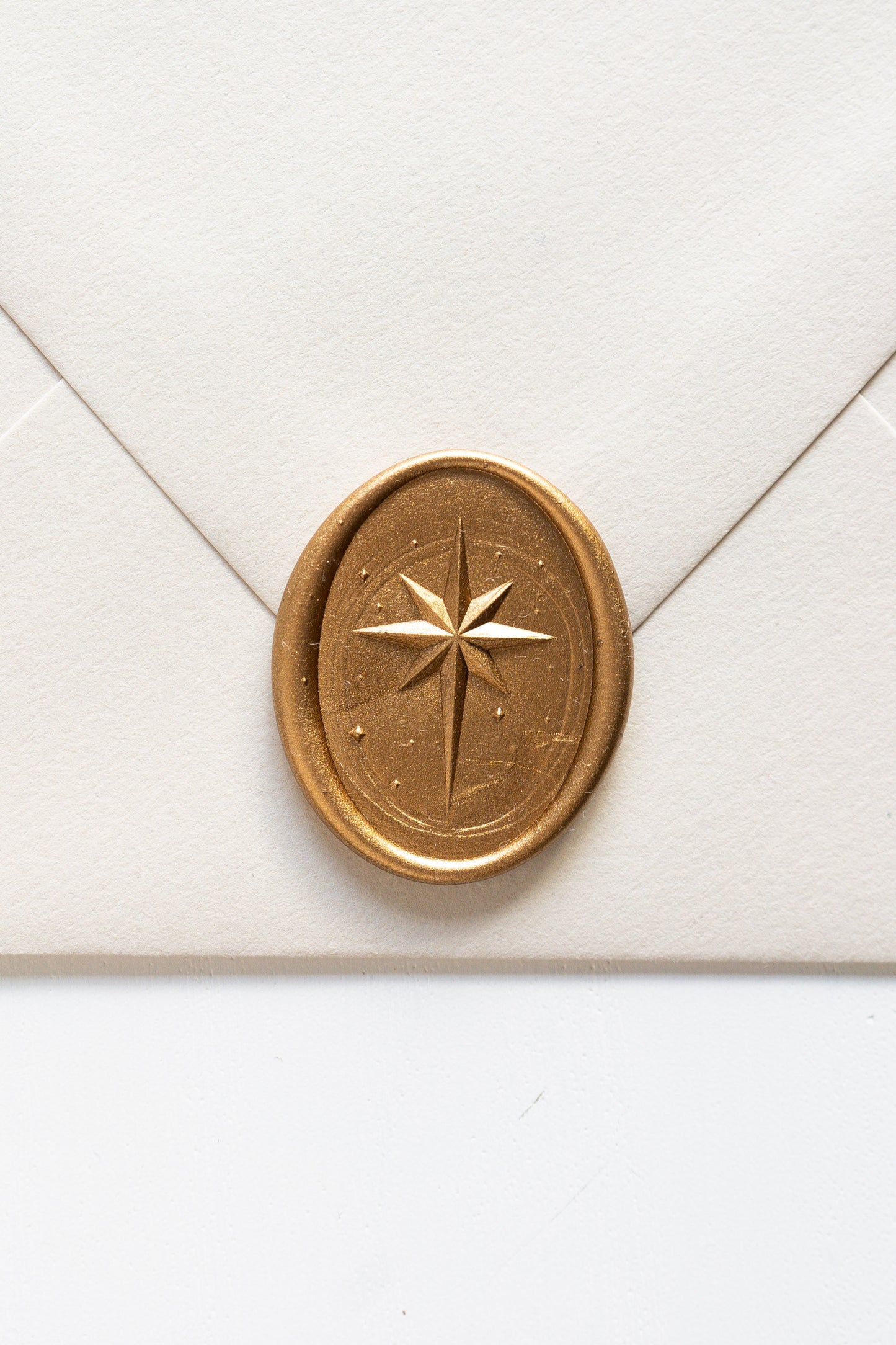 Gold star wax seal on cream envelope, elegant sealing wax detail for wedding invitations and holiday mail