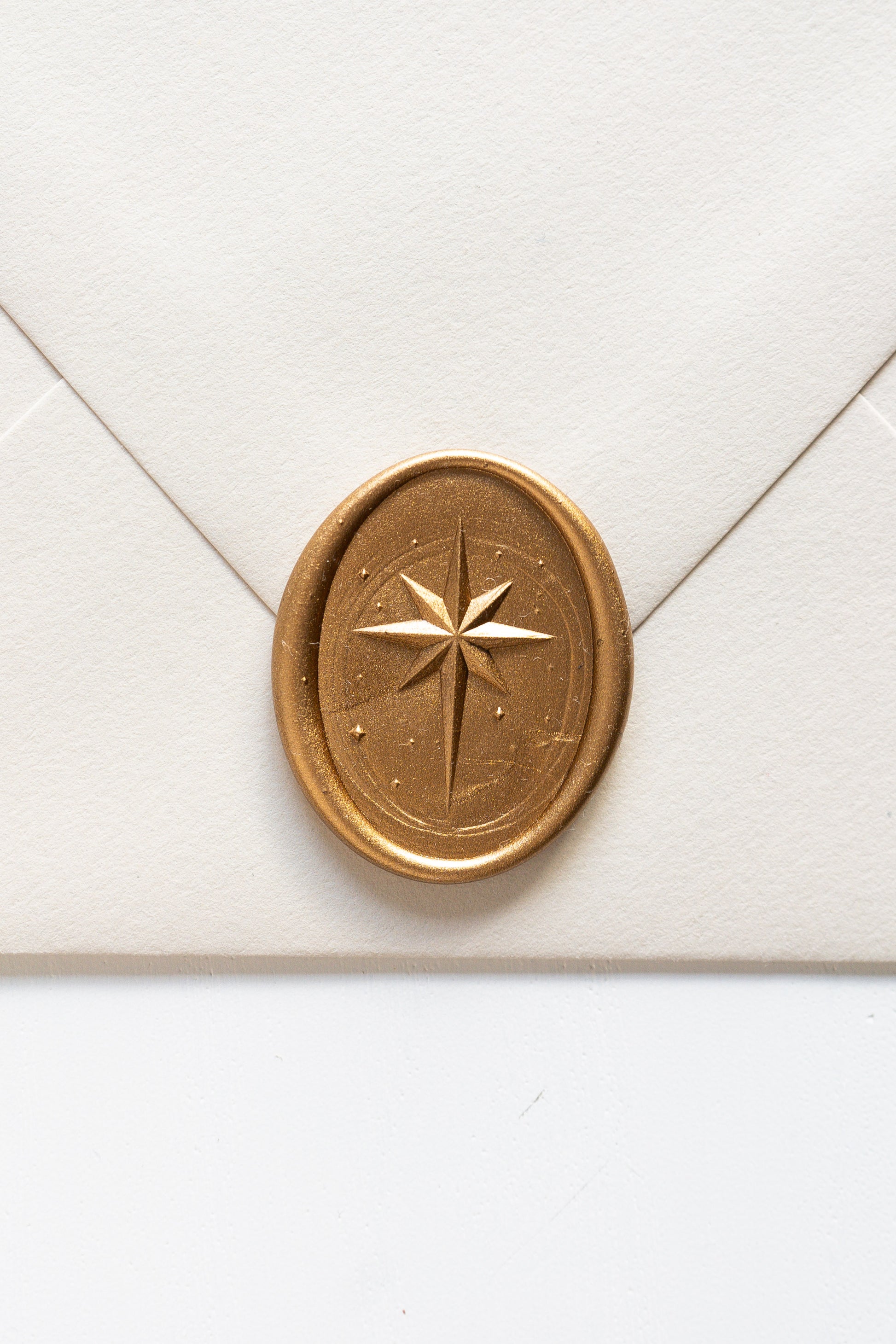 Gold star wax seal on cream envelope, elegant sealing wax detail for wedding invitations and holiday mail