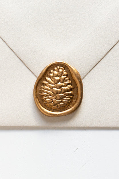 A beige envelope featuring a golden 3D pinecone wax seal, perfect for Holiday greeting cards