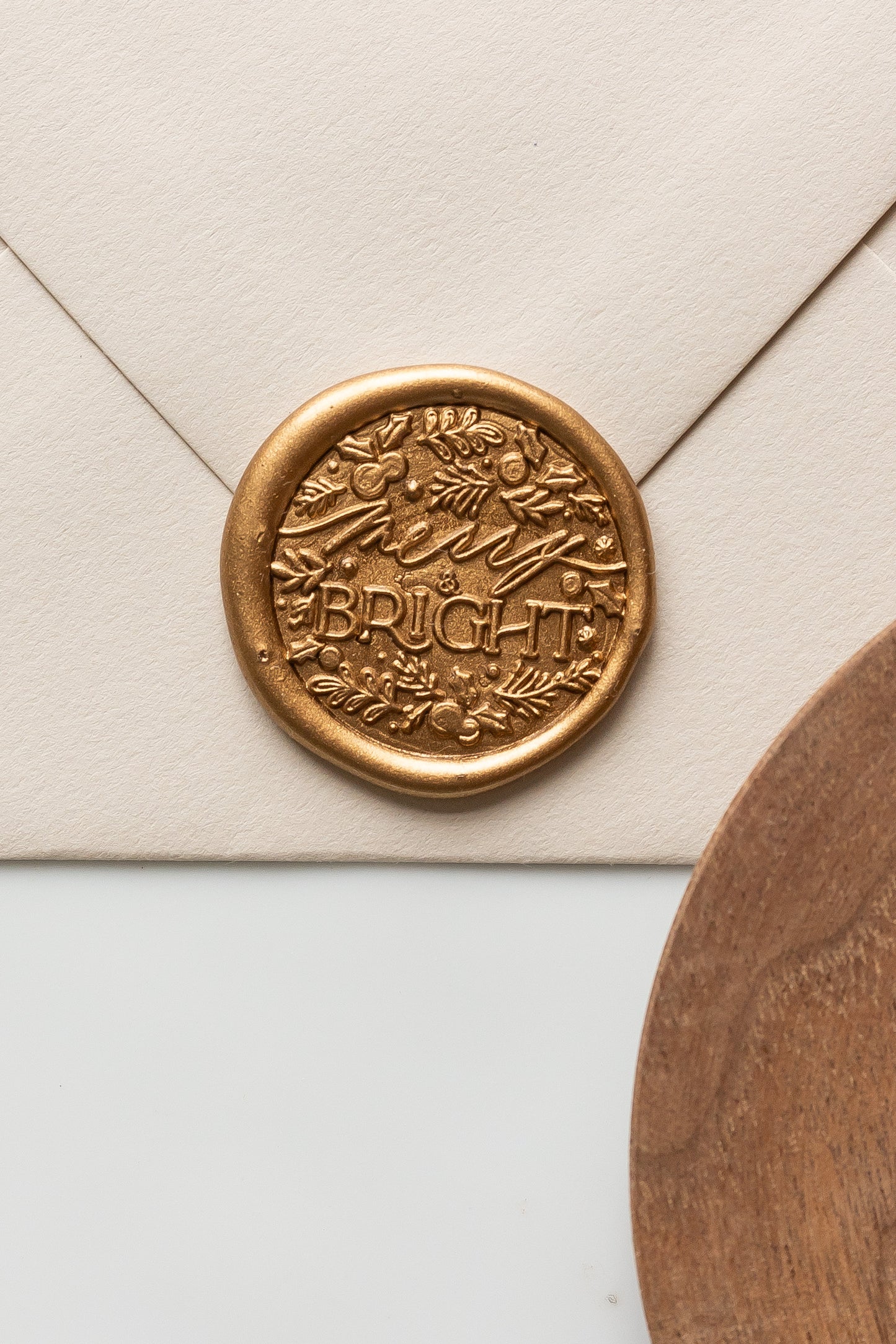 Gold wax seal featuring a “Merry & Bright” holiday design with festive foliage details, perfect for Christmas cards, gift wrapping, and holiday envelopes.