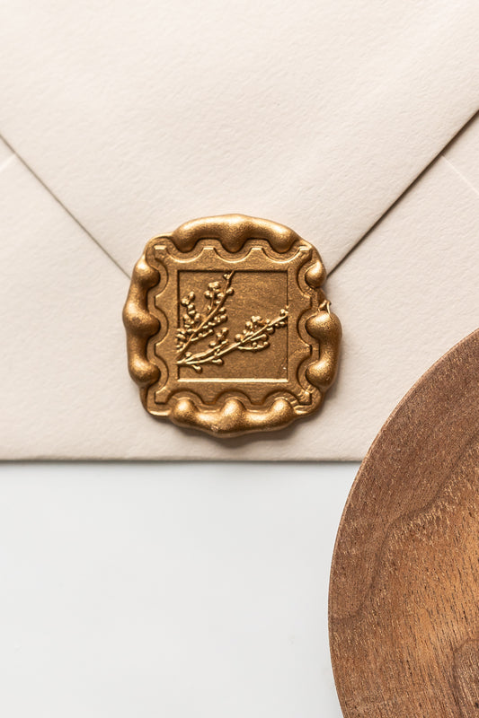 Close up of gold wax seal with winterberries stamp on envelope, classic wax seal for wedding stationery