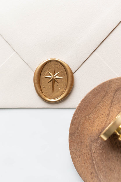 Gold wax seal with star motif on envelope beside wooden tray, classic wax sealing detail for letters