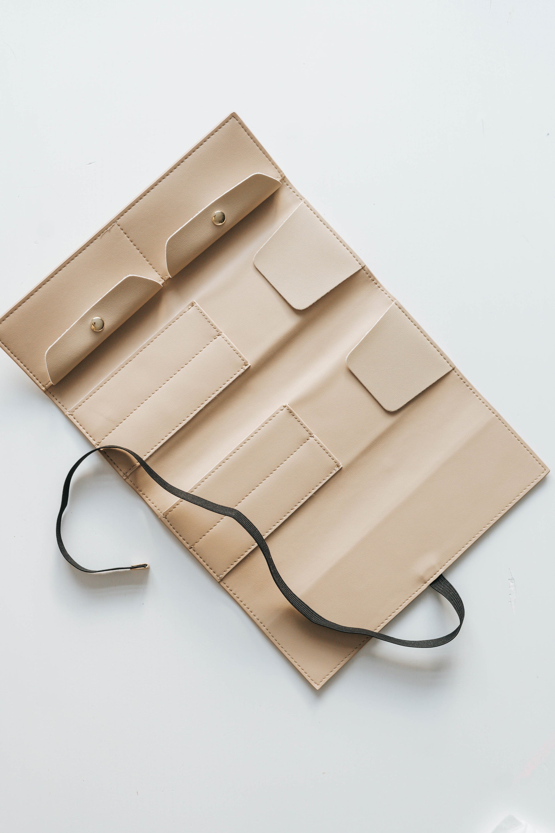 Empty beige calligraphy pen roll organizer with multiple slots and snap compartments