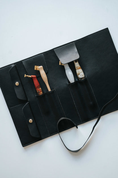 Black calligraphy pen roll with oblique penholders secured in individual slots