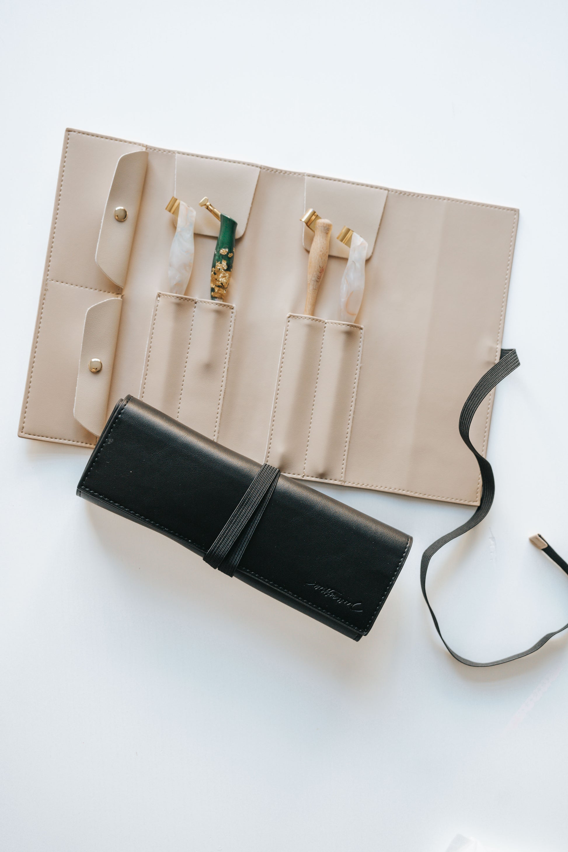 Open calligraphy pen roll showing multiple oblique penholders neatly stored in beige organizer