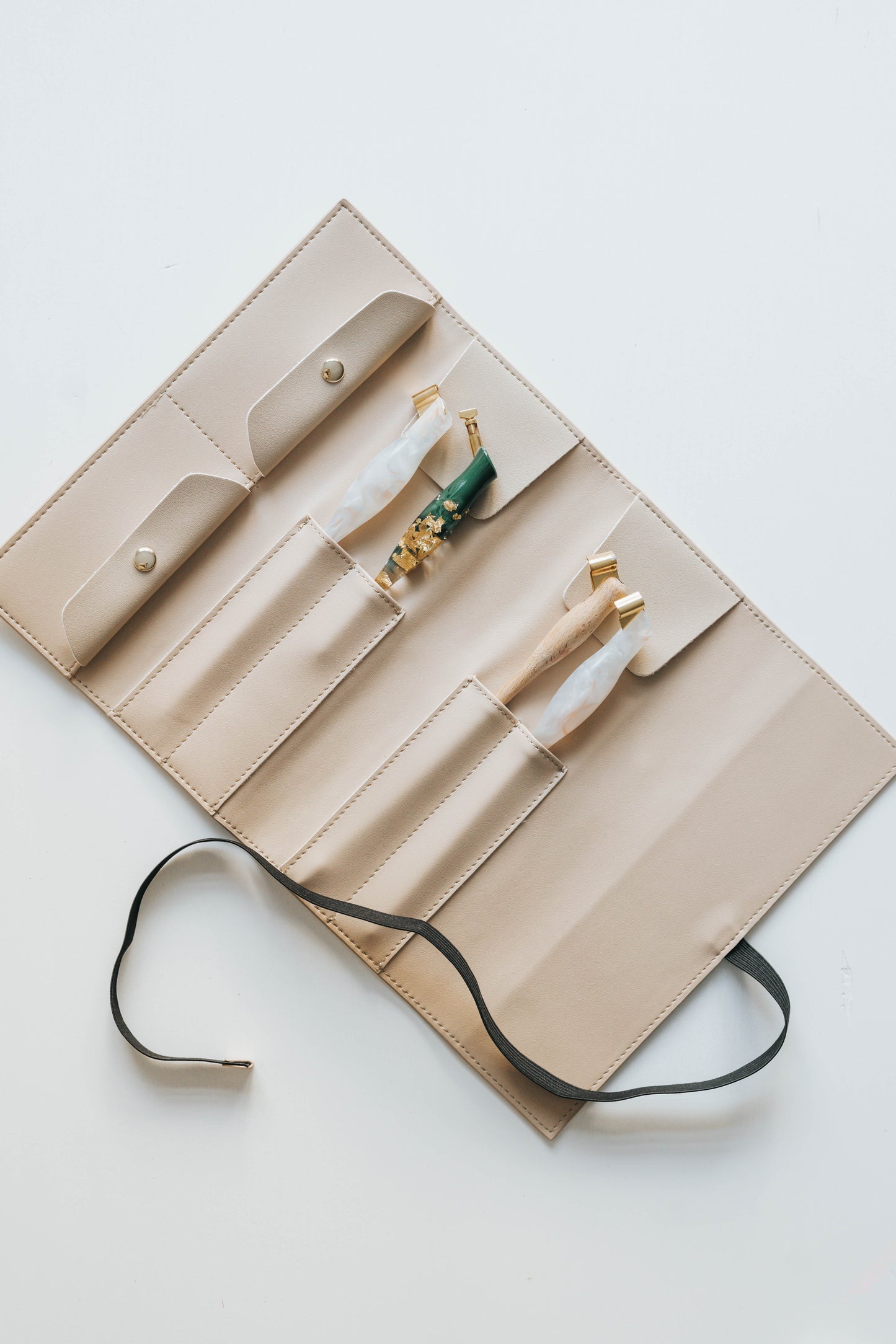 Beige calligraphy pen roll with oblique penholders and elastic tie for secure storage