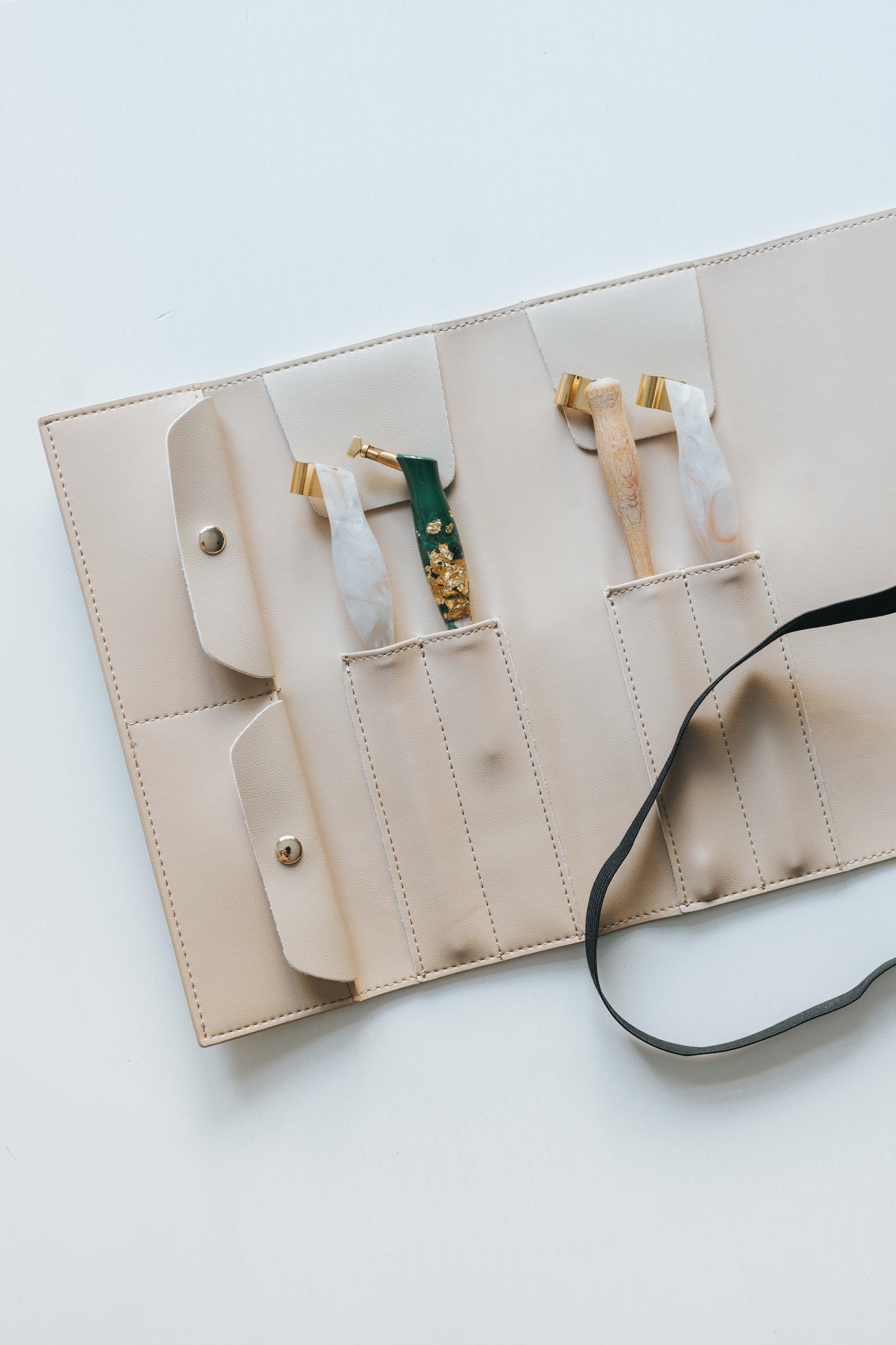 Beige calligraphy pen roll with oblique penholders stored in stitched compartments