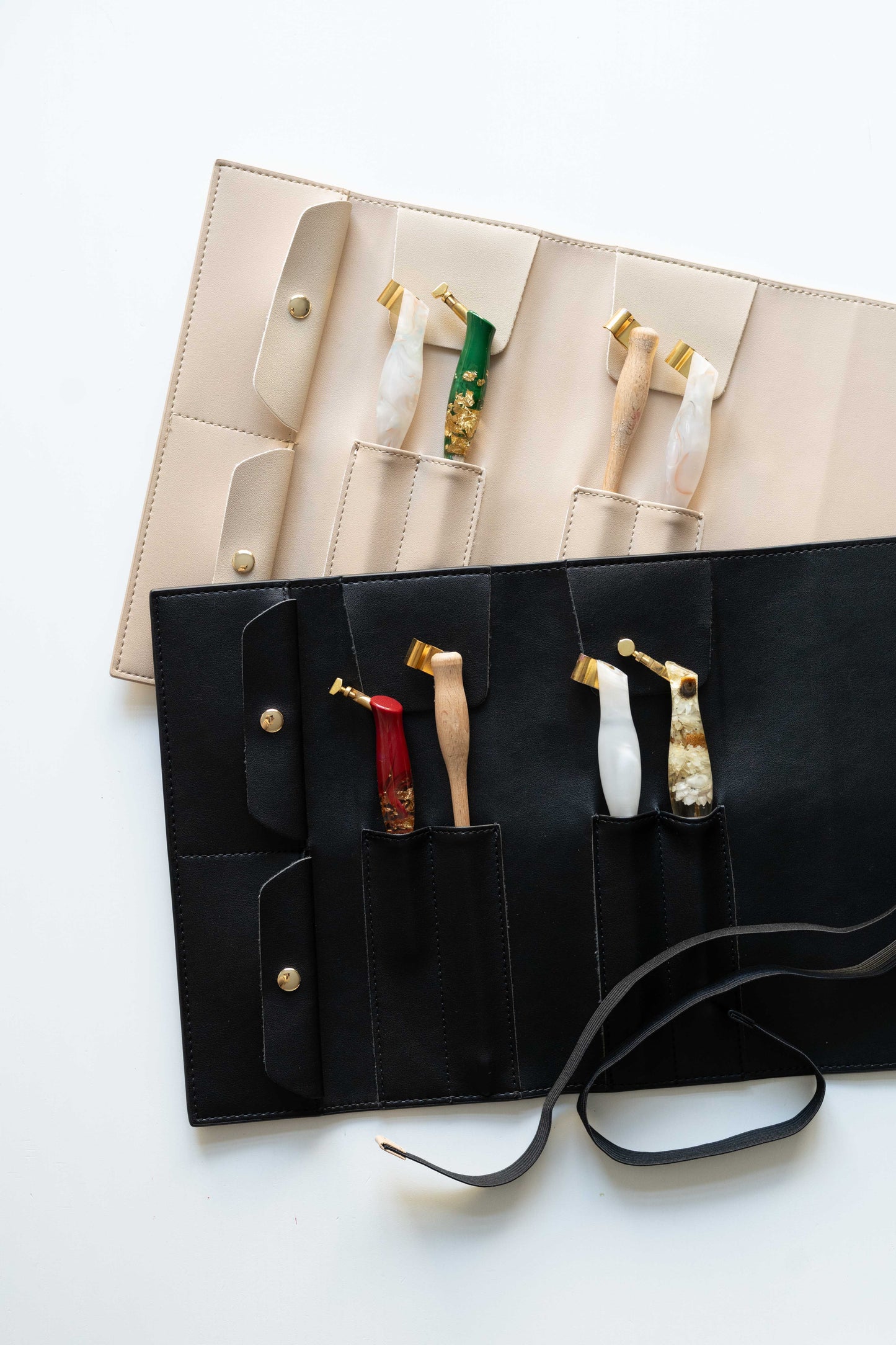 Beige and black calligraphy pen rolls displayed with oblique penholders inside