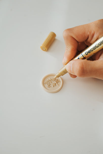 Marvy Uchida DecoColor Premium Fine Point gold paint pen with a beige wax seal