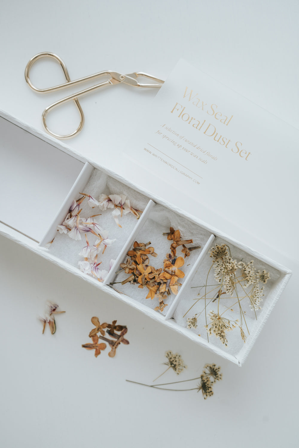 Wax Seal Floral Dust Set with dried flowers in a white box, perfect for decorating wax seals. Gold tweezers included.