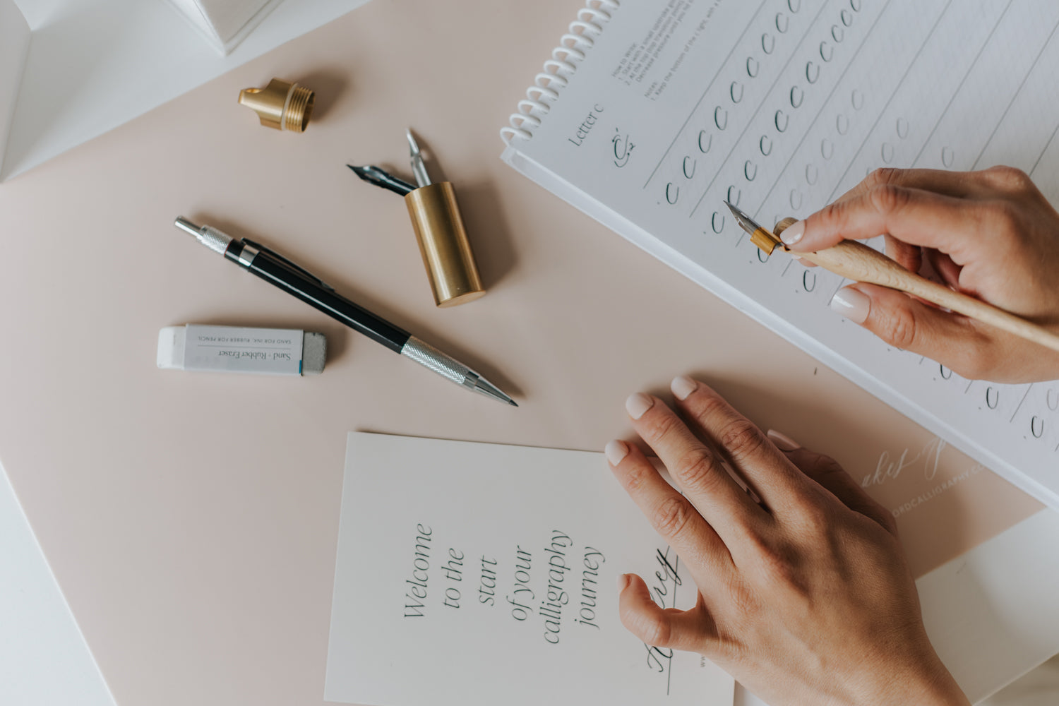 Beginner practicing modern calligraphy with pointed pen, nib holder, workbook, and calligraphy worksheets from an online course.