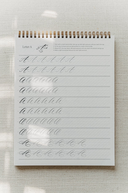 Modern calligraphy practice pad featuring the letter "A" with tracing guides for uppercase letters