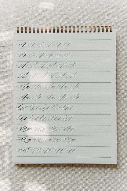 Calligraphy practice pad with drills for the letter "A," combining various letter combinations and strokes