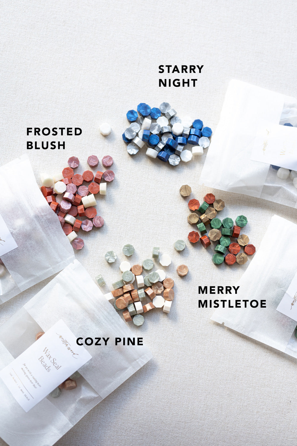 Assorted wax seal beads in four gradients, labeled and spilling from translucent pouches onto a white surface