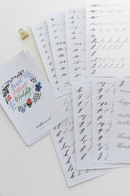 Brush lettering worksheet pages laid out next to each other on a white surface