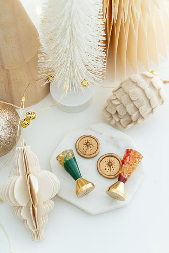 Pair of Star of Bethlehem wax seal stamps in red and green resin with gold flakes, limited edition holiday design.