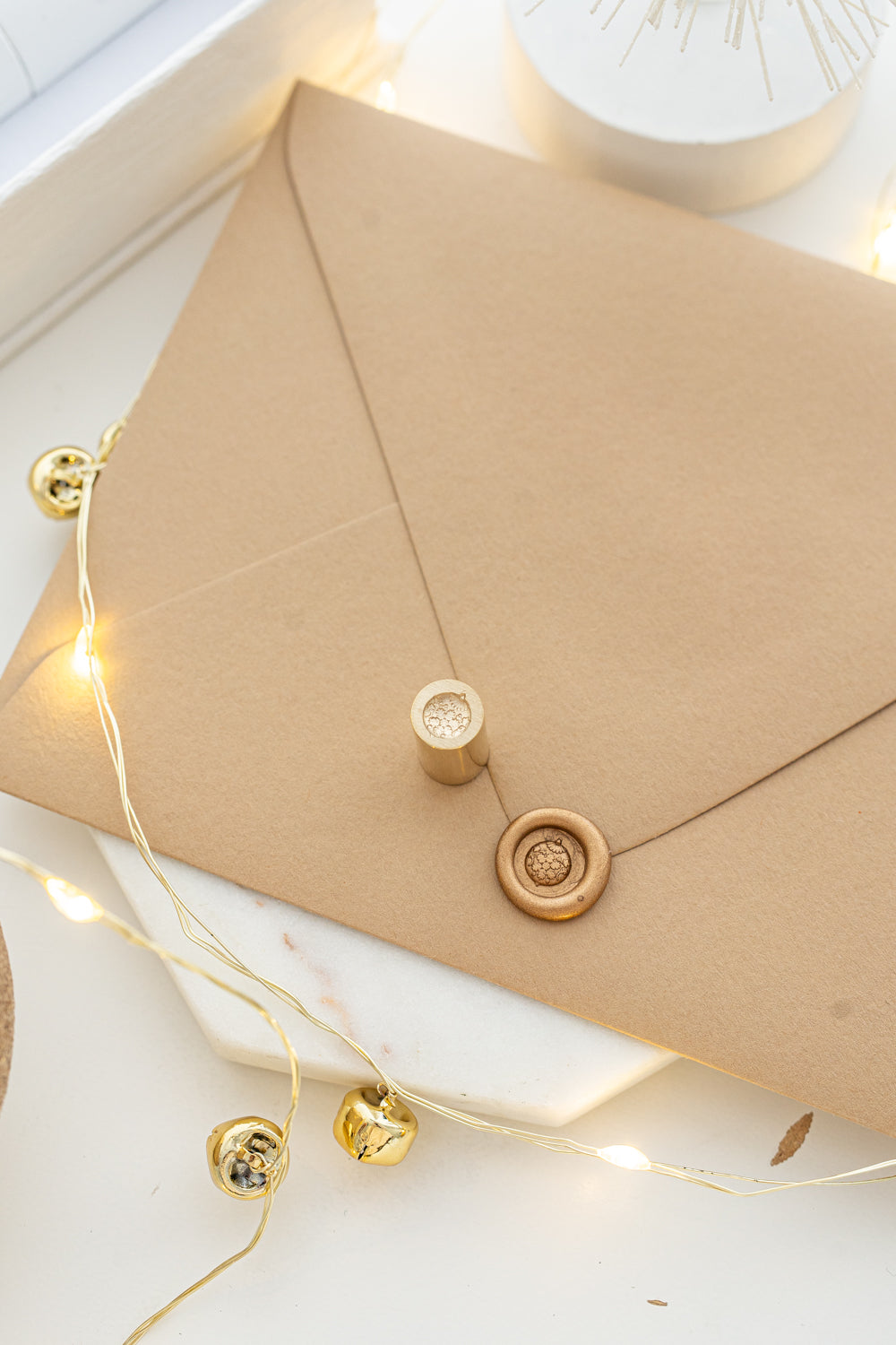 Cozy holiday mini wax seal stamp with round ornament design in gold wax on a kraft envelope, part of Written Word Calligraphy’s Holiday Collection.