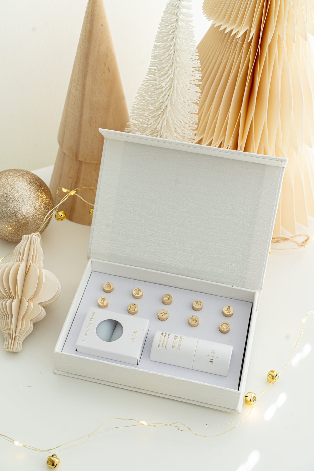 Open Holiday Mini Wax Seal Head Set from Written Word Calligraphy, featuring twelve festive brass stamp designs arranged neatly in a white gift box with soft holiday décor.