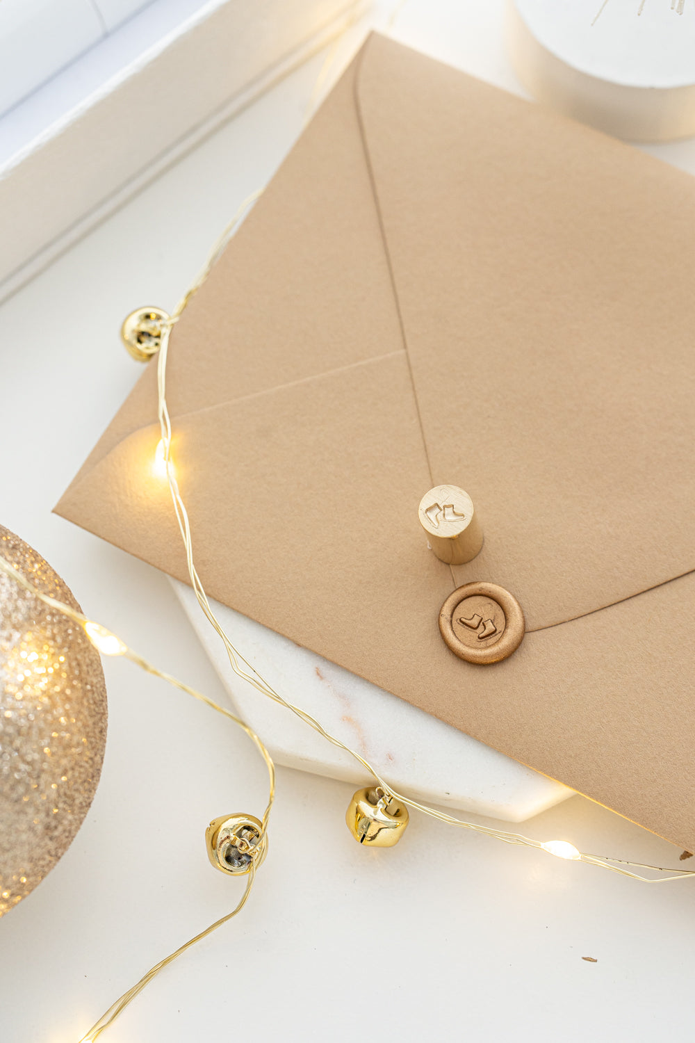 Holiday mini wax seal stamp with ice skates design in gold wax on a kraft envelope, part of Written Word Calligraphy’s Holiday Collection.
