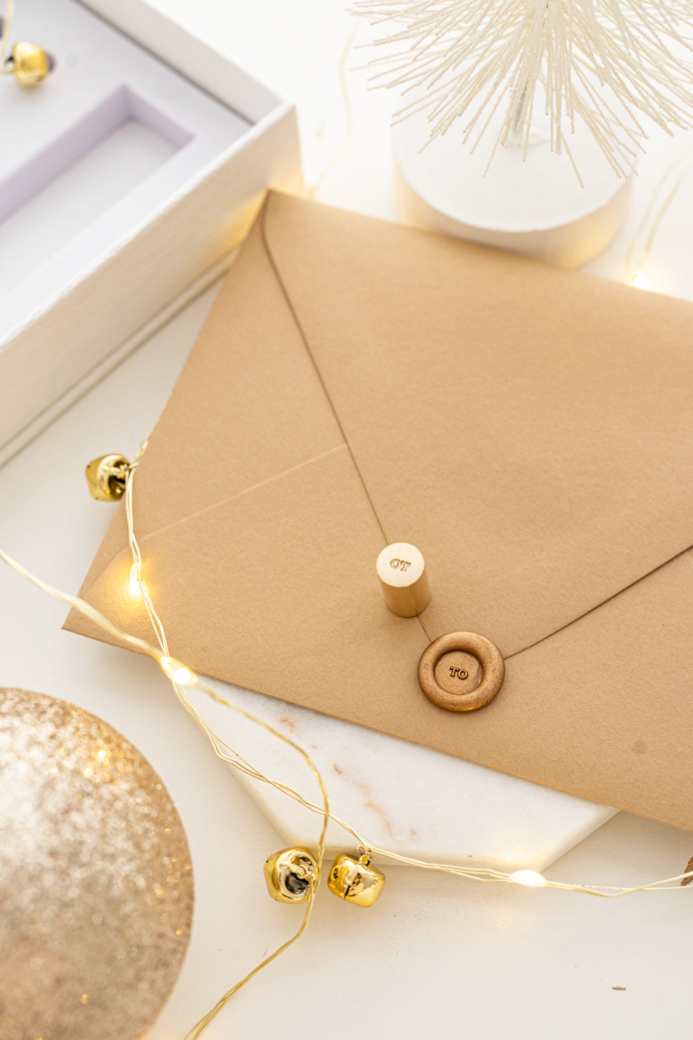 Mini wax seal stamp with “TO” design in gold wax on a kraft envelope, part of Written Word Calligraphy’s Holiday Collection.