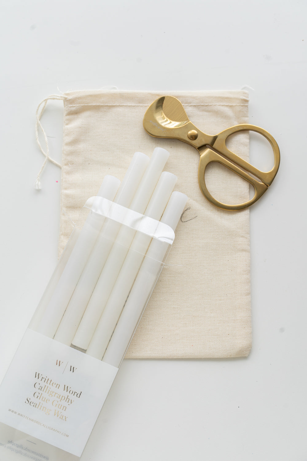 Set of vellum sealing wax sticks with a pair of scissors and a drawstring bag on a white background