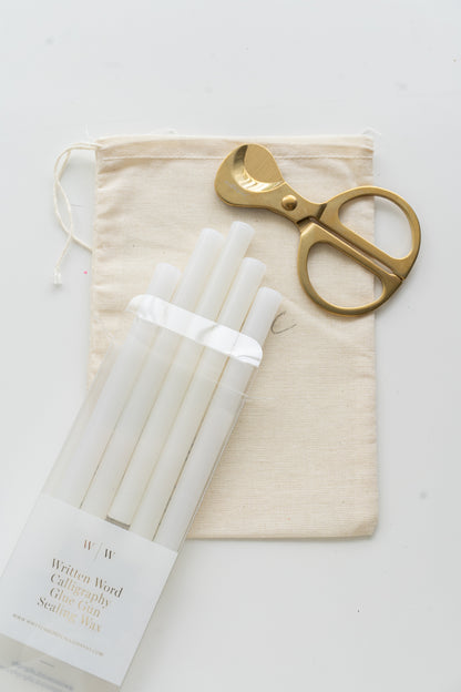 Set of vellum sealing wax sticks with a pair of scissors and a drawstring bag on a white background