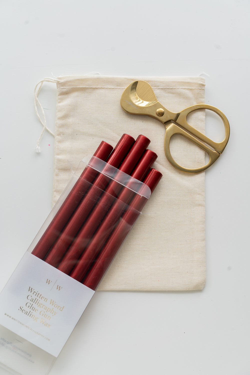 Set of lunar red sealing wax sticks with a pair of scissors and a drawstring bag on a white background