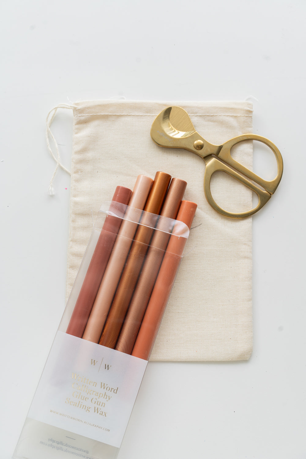 Set of golden hour sealing wax sticks with a pair of scissors and a drawstring bag on a white background