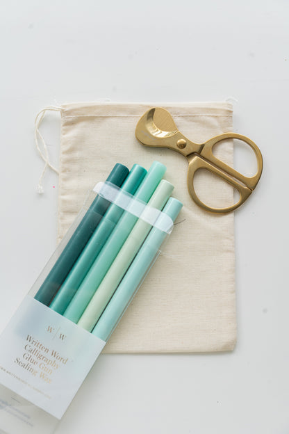 Set of deep lagoon sealing wax sticks with a pair of scissors and a drawstring bag on a white background