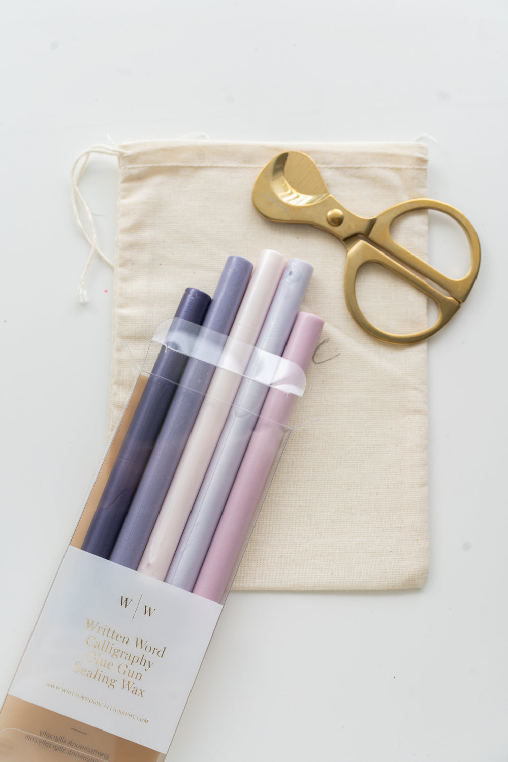 Set of wisteria sealing wax sticks with a pair of scissors and a drawstring bag on a white background