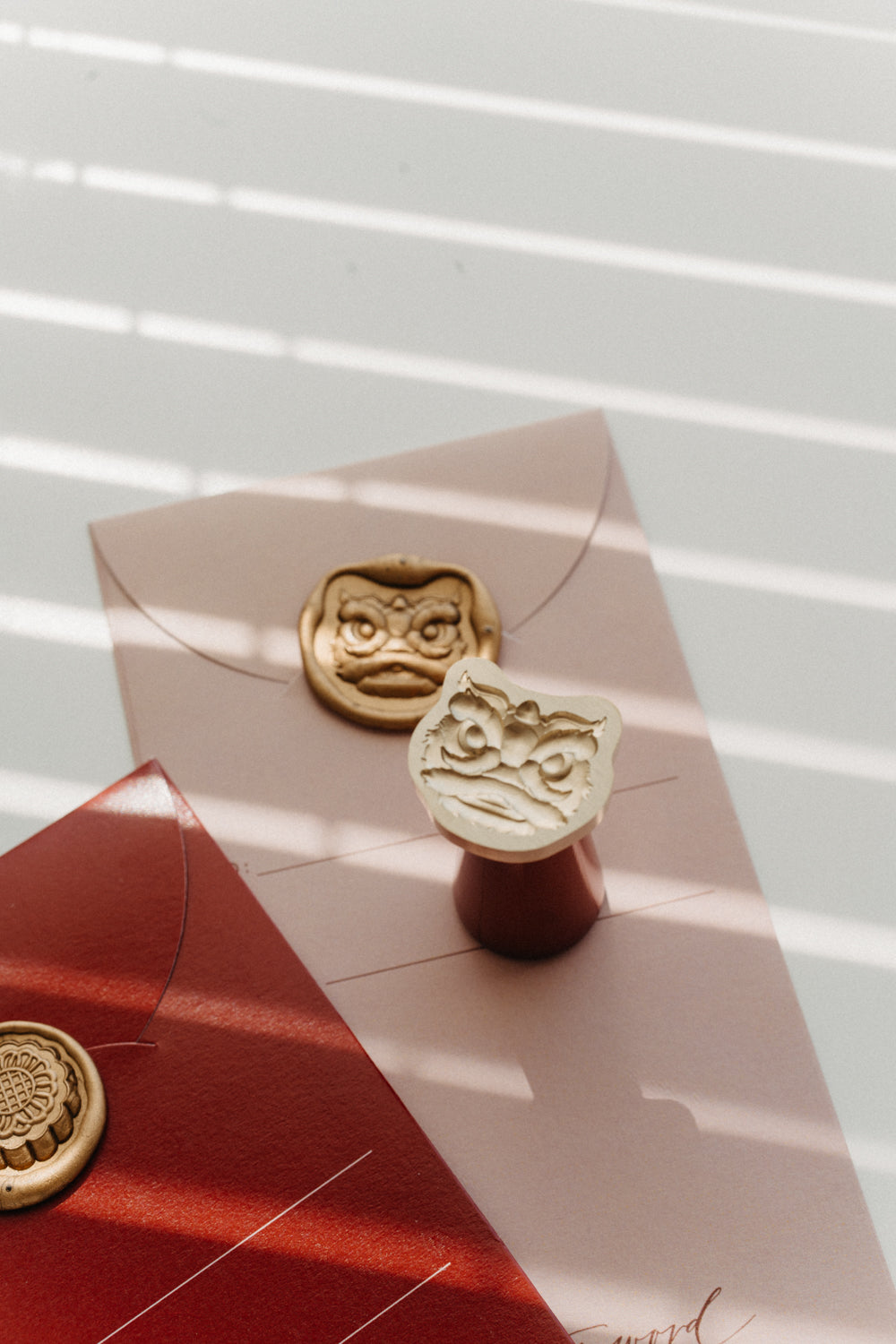 Mooncake and Lion Dance wax seal designs shown together on envelopes