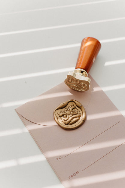 Lion Dance wax seal stamp with wooden handle beside finished wax seal impression