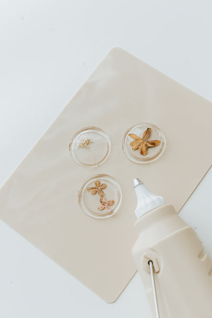 Clear floral wax seals on silicone mat with glue gun 