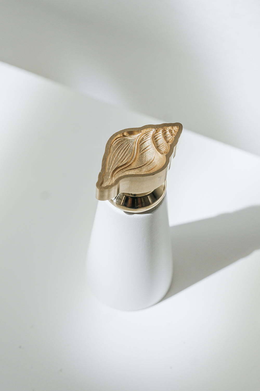 Engraved Conch brass wax seal stamp with white handle for creating elegant wax seals on invitations, envelopes, and gifts.