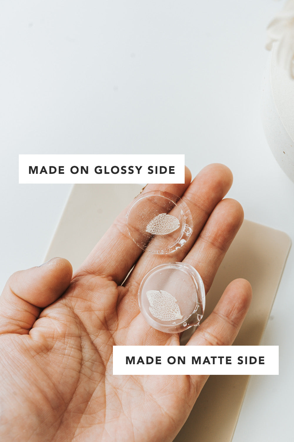 Clear wax seals showing glossy and matte sides held in hand for comparison