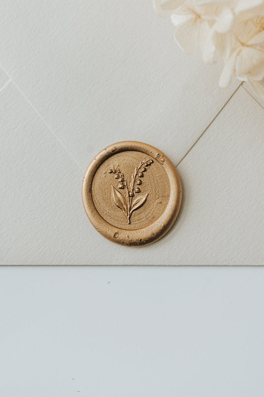 Lily of the valley wax seal with gold sealing wax on textured envelope for elegant mail styling