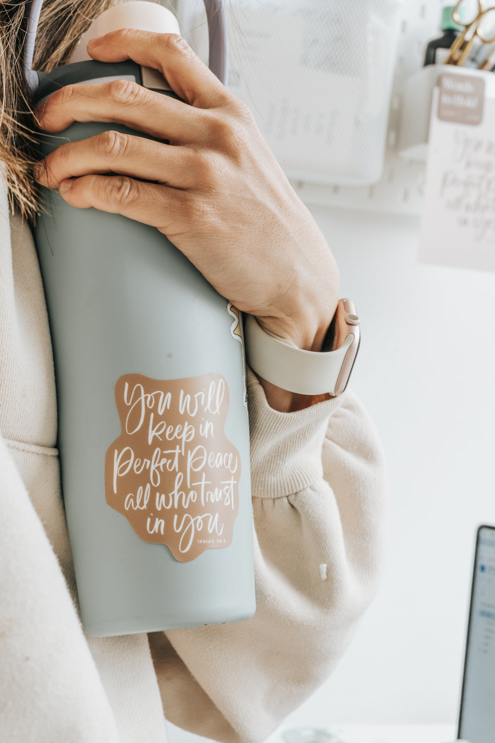 Hand holding insulated tumbler with Christian calligraphy sticker, Isaiah 26:3 verse, neutral aesthetic