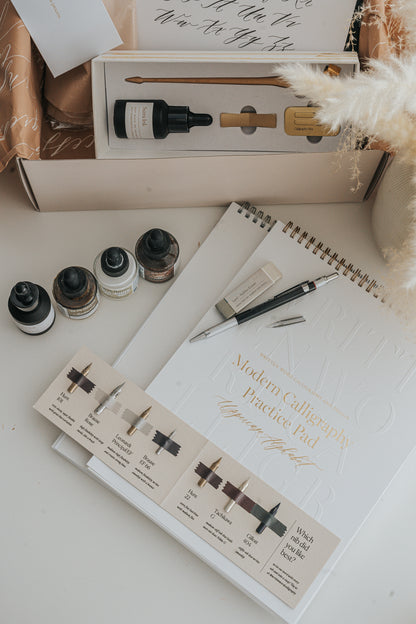 Calligraphy supplies set with ink bottles, nib sampler, pen holder, and practice pad