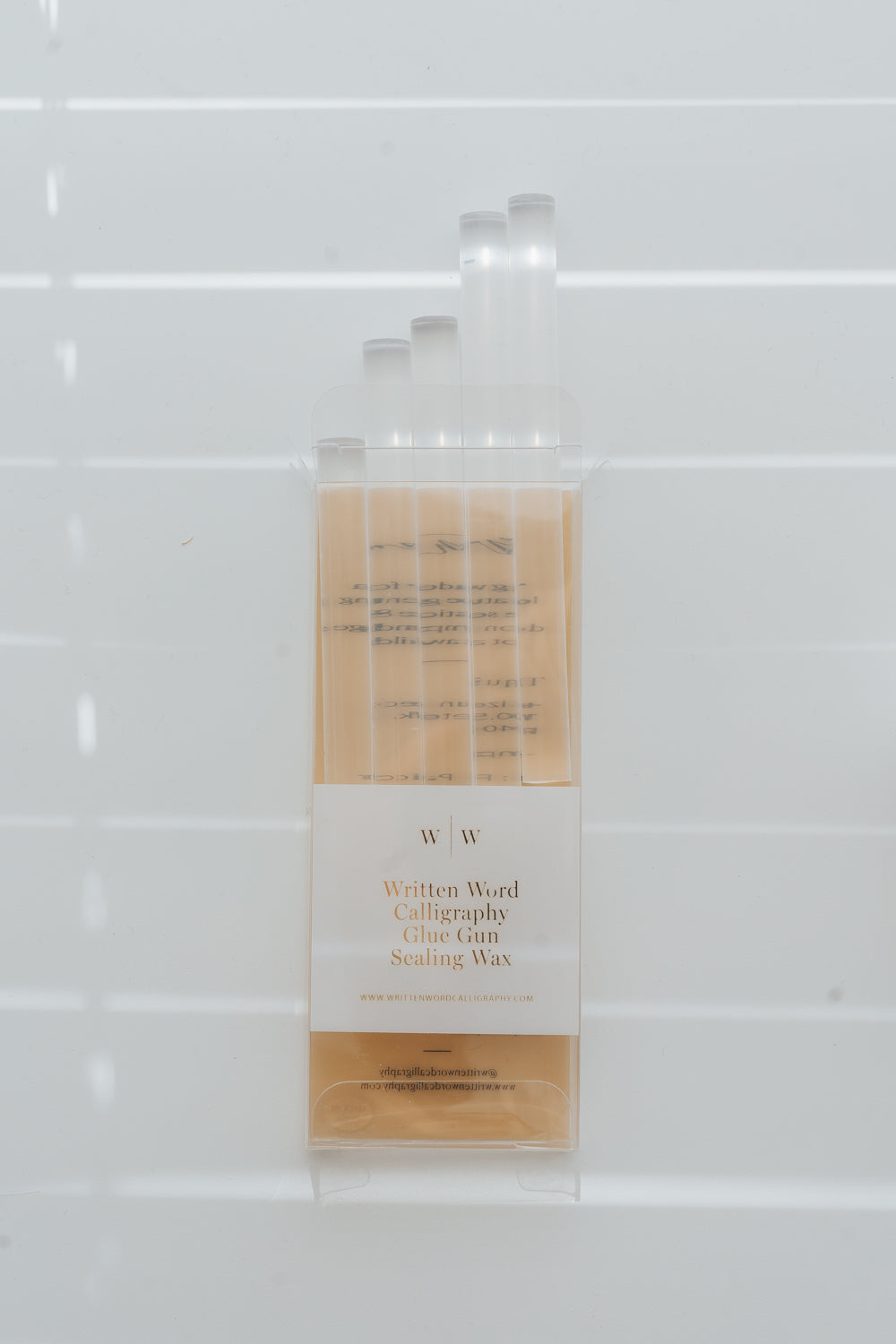 Clear sealing wax sticks in packaging with soft window light shadows
