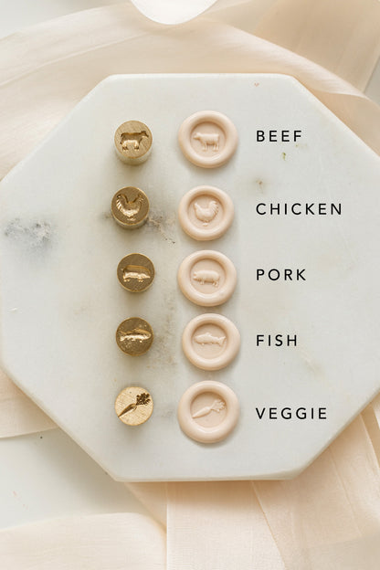Marble coaster with meat and vegetable mini wax seal stamps labeled on a beige background