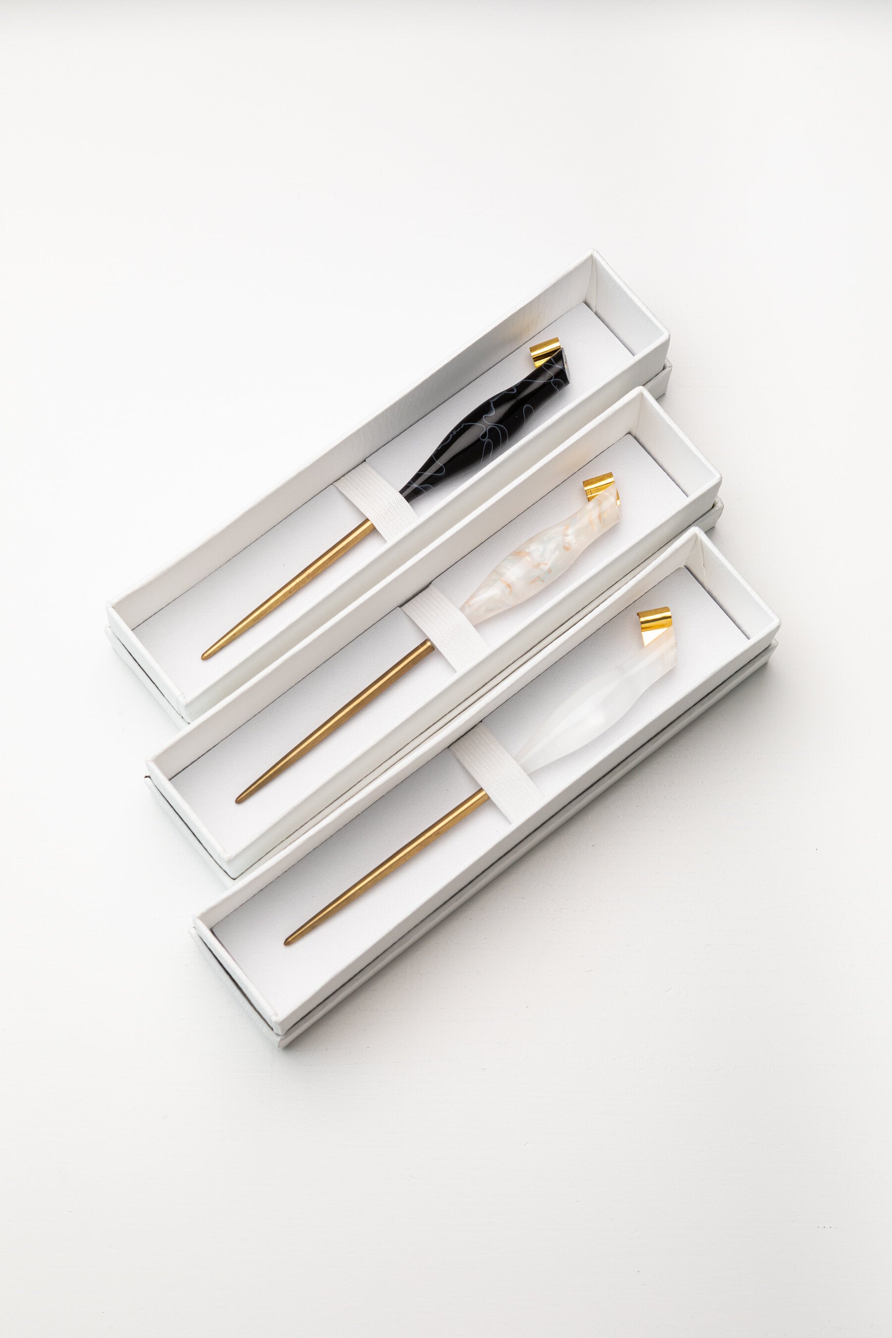 Set of three handmade oblique calligraphy pens with resin bodies, brass tips, and ergonomic designs, presented in gift boxes